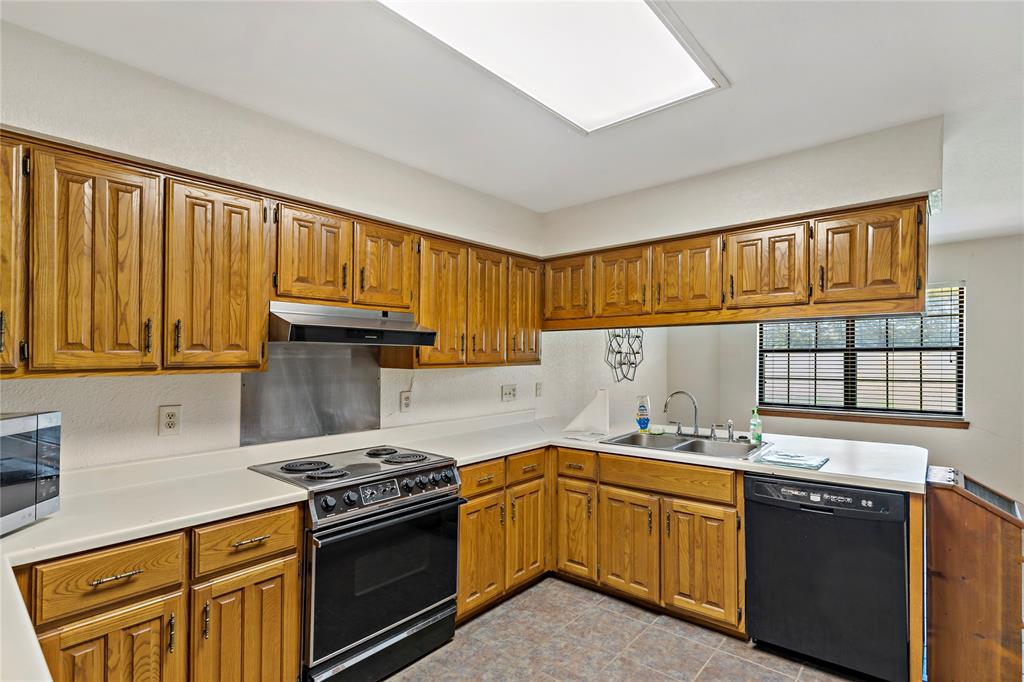 4395 Farm Road 2820 Brookston, TX 75421 - Photo 17 of 33 a kitchen with granite countertop a sink cabinets stainless steel appliances and a window