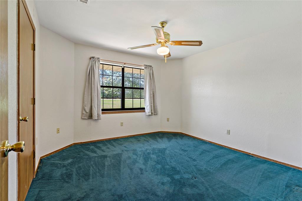 4395 Farm Road 2820 Brookston, TX 75421 - Photo 19 of 33 an empty room with windows and fan