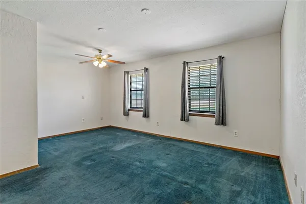 an empty room with closet and a chandelier fan