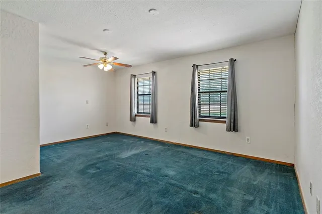 an empty room with closet and a chandelier fan