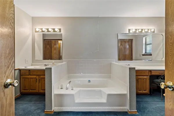 a en suite bathroom with a double vanity sink and a mirror
