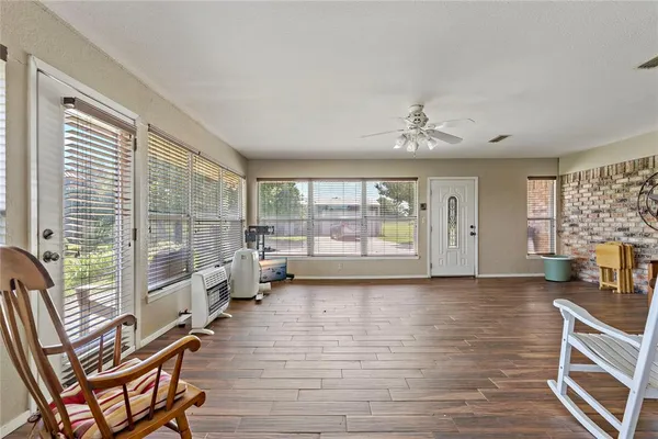 a living room with furniture floor to ceiling window and wooden floor