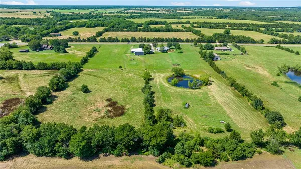 an aerial view of a houses with outdoor space and trees