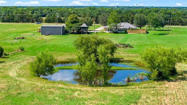 an aerial view of a house with yard outdoor seating and lake view