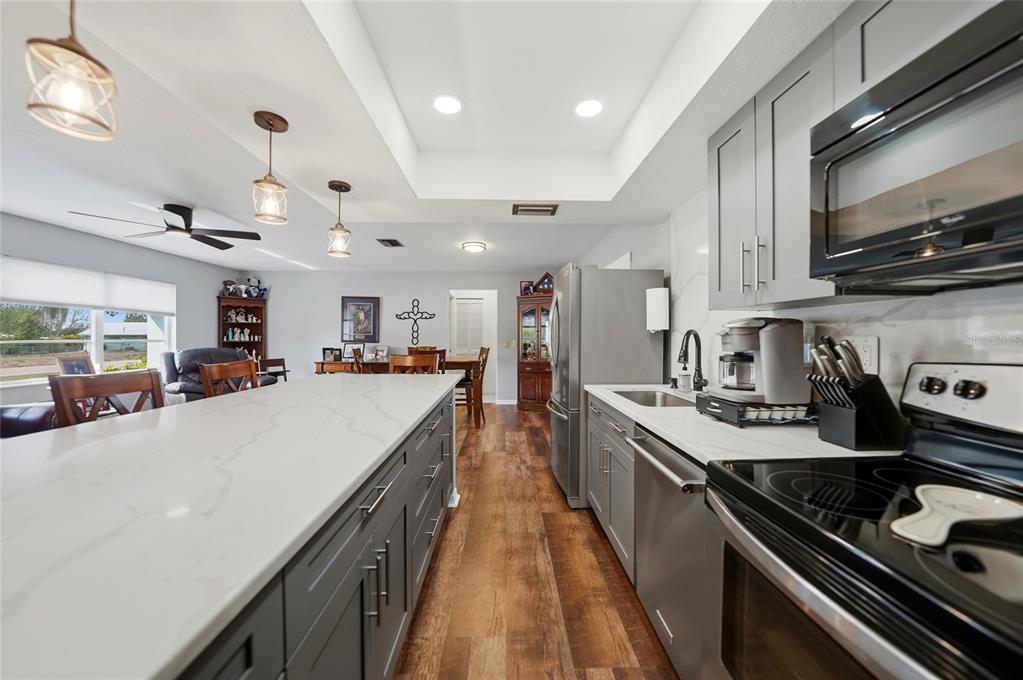 405 Ridgecrest Drive Punta Gorda, FL 33982 - Photo 6 of 30 a kitchen with kitchen island granite countertop lots of counter top space a sink and stainless steel appliances
