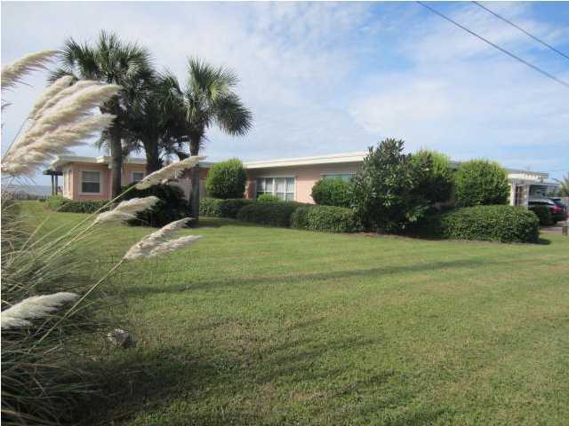 570 Blue Mountain Road Santa Rosa Beach, FL 32459 - Photo 1 of 24 a view of a garden with a building in the background