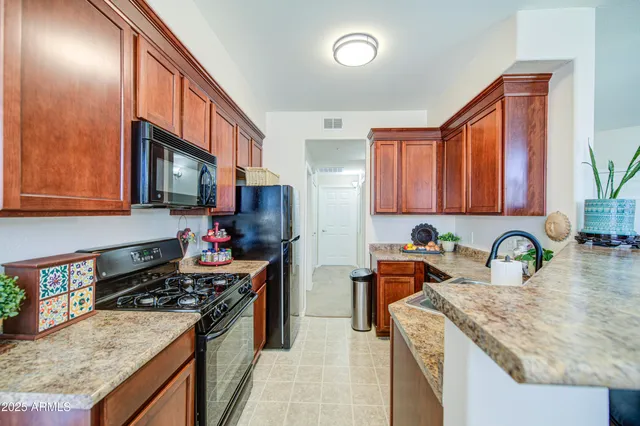 a kitchen with stainless steel appliances granite countertop a stove a sink and a microwave