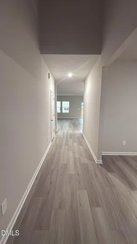 a view of a big room with wooden floor and windows