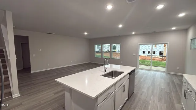a kitchen that has a sink and a microwave with wooden floor