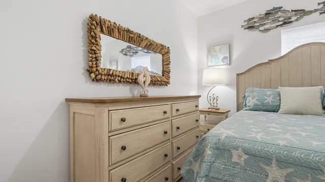 a bedroom with a bed and a mirror on dresser