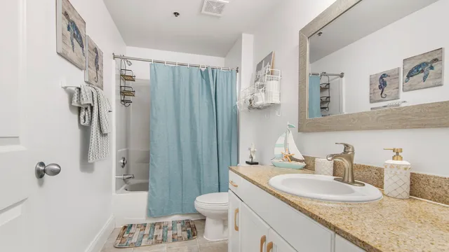 a bathroom with a granite countertop sink a toilet and shower