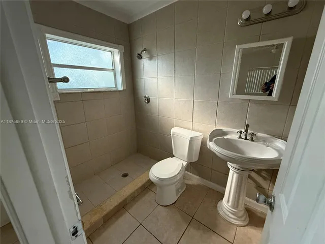 a bathroom with a sink toilet and a mirror