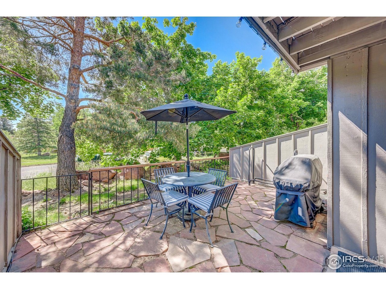 1265 Bear Mountain Drive, Unit B Boulder, CO 80305 - Photo 21 of 24 a view of a patio with table and chairs under an umbrella