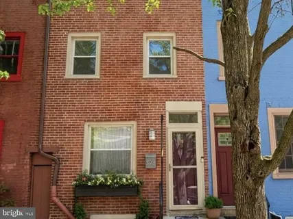 a view of a brick house with a door and a large window