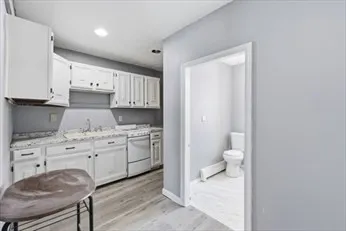 a spacious bathroom with a granite countertop sink and a toilet