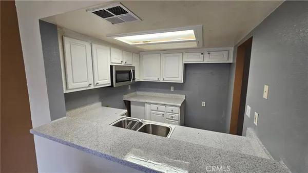 a kitchen with stainless steel appliances granite countertop a refrigerator a stove top oven a sink and dishwasher