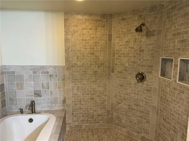 a bathroom with a tub shower and a sink