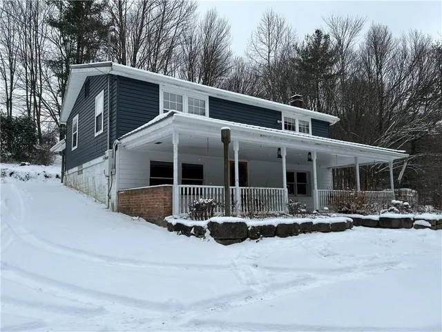 a front view of house with yard and trees in the background