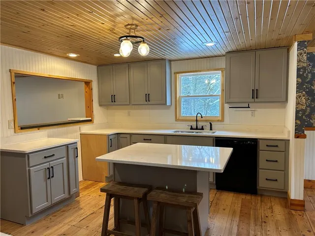 a kitchen with a sink cabinets and wooden floor