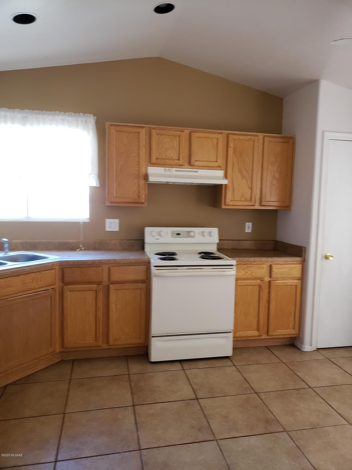 1200 Desert Dawn Drive Rio Rico, AZ 85648 - Photo 3 of 24 a kitchen with a stove a sink and a refrigerator