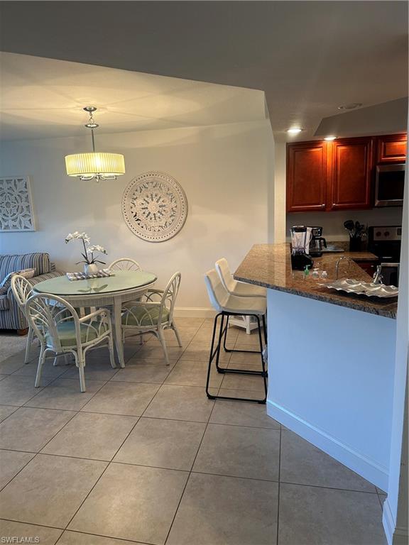 1950 West Crown Pointe Boulevard, Unit B106 Naples, FL 34112 - Photo 13 of 33 a dining room with a table chairs and a kitchen view