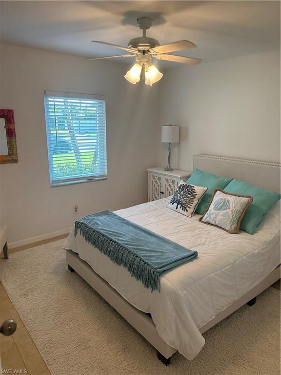 1950 West Crown Pointe Boulevard, Unit B106 Naples, FL 34112 - Photo 9 of 33 a bedroom with a bed and a chandelier
