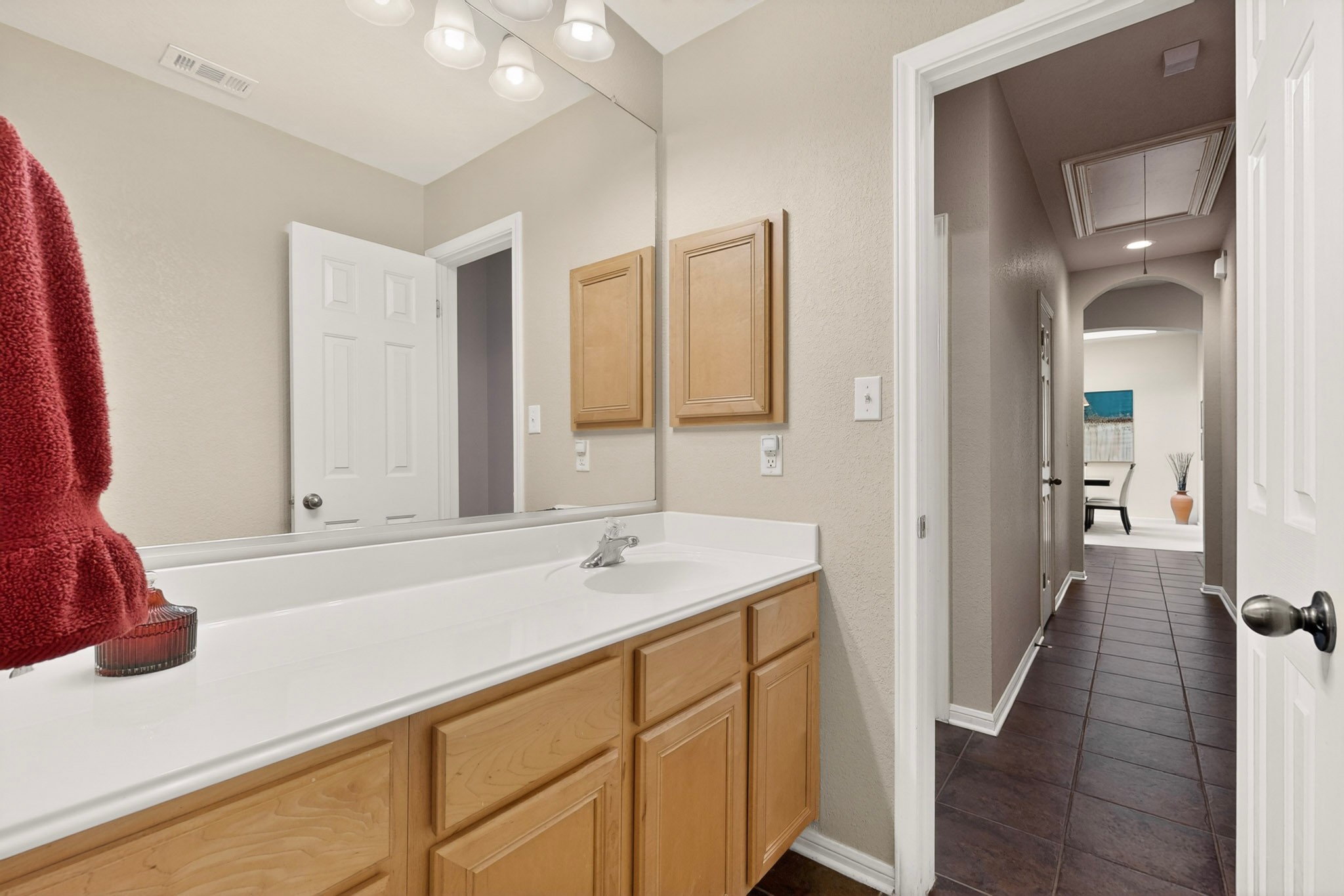 905 Victoria Ridge Drive Pflugerville, TX 78660 - Photo 20 of 32 Ample counter space and functional cabinetry define this well-appointed bath, leading to a long hallway with tiled flooring.