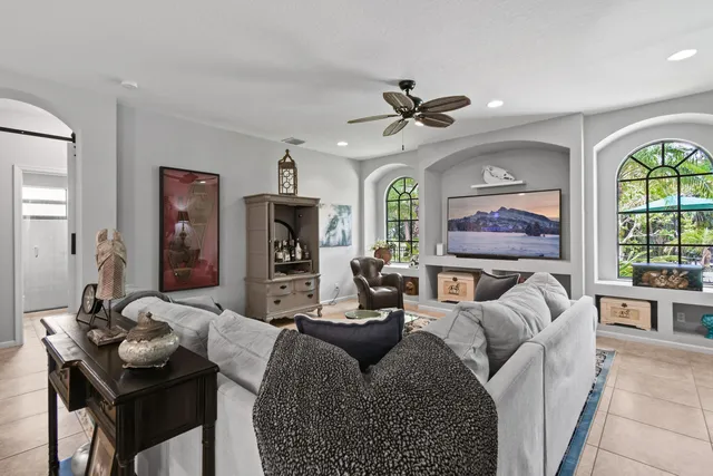a living room with furniture ceiling fan and a window