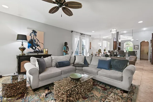 a living room with furniture a fireplace and a chandelier