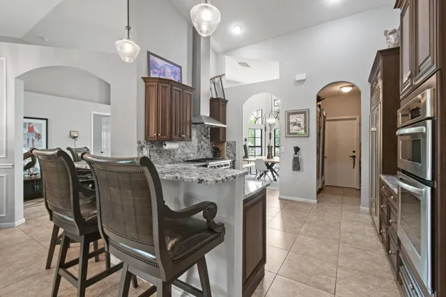 a large kitchen with granite countertop a sink and cabinets