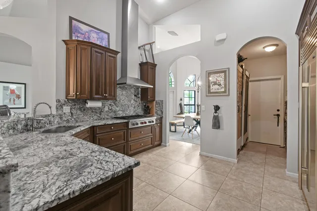a kitchen with stainless steel appliances kitchen island granite countertop a refrigerator and cabinets