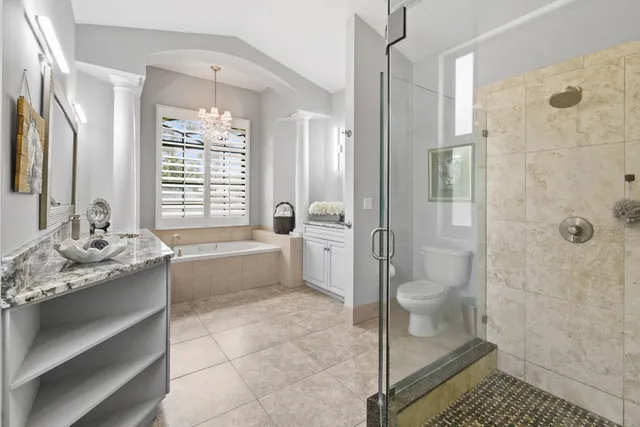 a bathroom with a granite countertop sink a large mirror a bathtub and next to a window