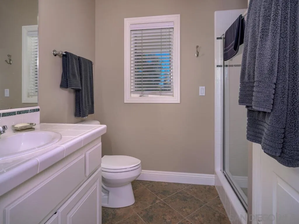 14490 Ridge Ranch Road Escondido, CA 92027 - Photo 40 of 74 a bathroom with a granite countertop toilet a sink and a mirror