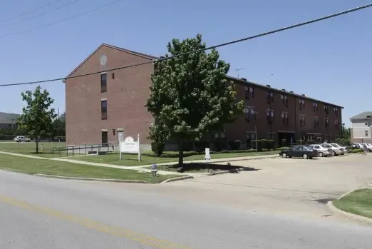 a backyard of a house with a table and chairs under an umbrella
