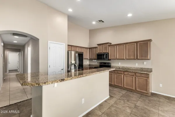 a large kitchen with kitchen island a sink stainless steel appliances and cabinets