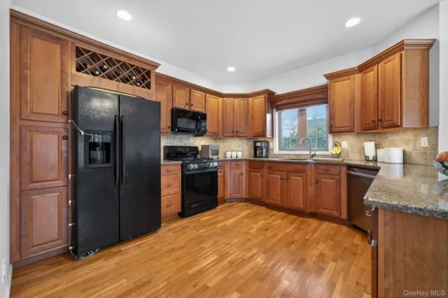 a kitchen with granite countertop stainless steel appliances a refrigerator sink microwave and cabinets