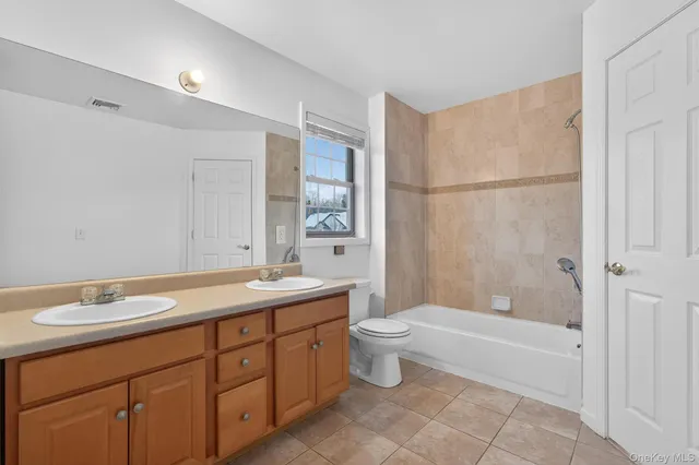 a bathroom with a sink vanity granite and toilet