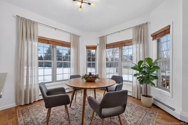 a dining room with furniture potted plants and wooden floor
