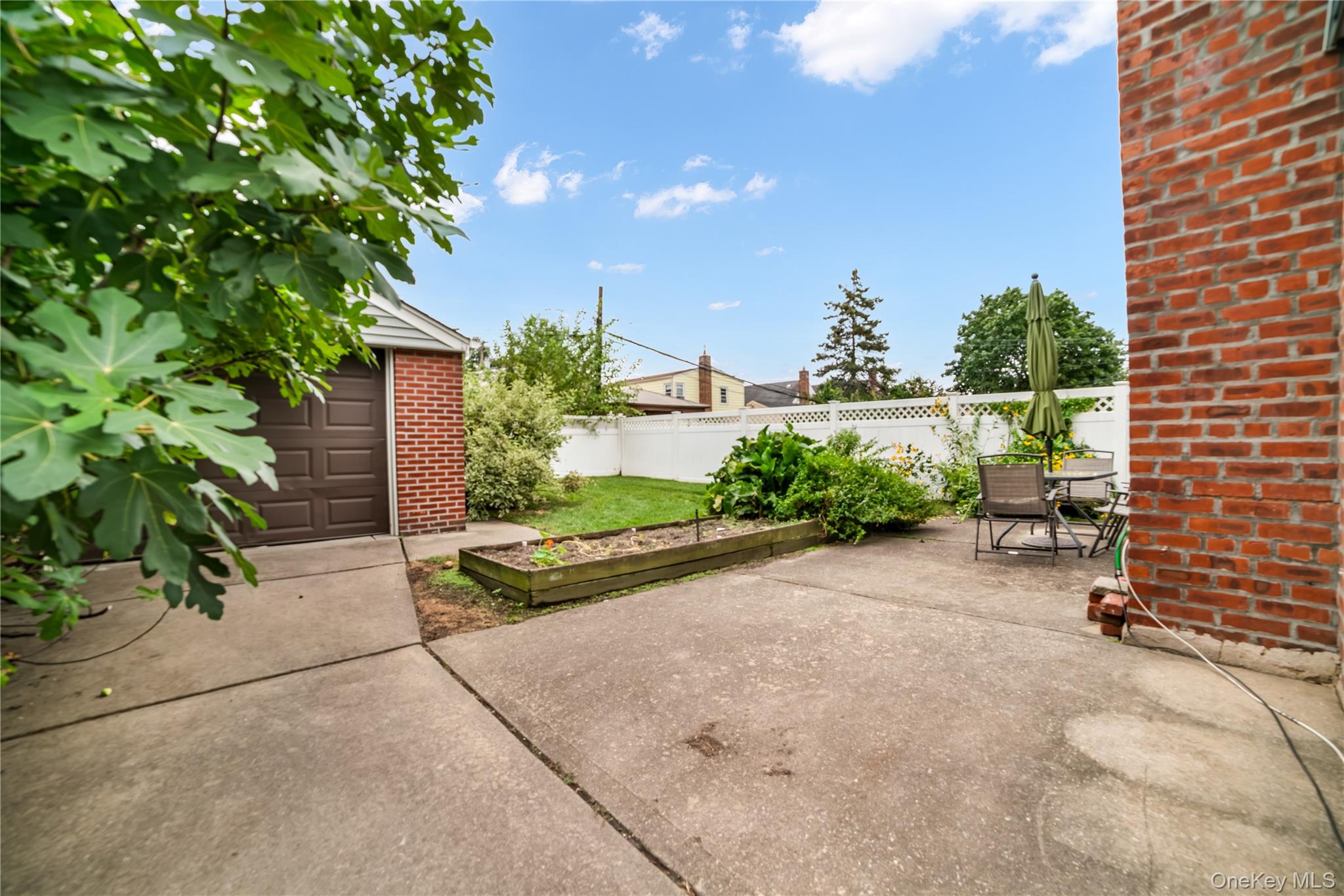 77-19 252nd Street Queens, NY 11426 - Photo 26 of 27 a view of a patio with table and chairs and potted plants