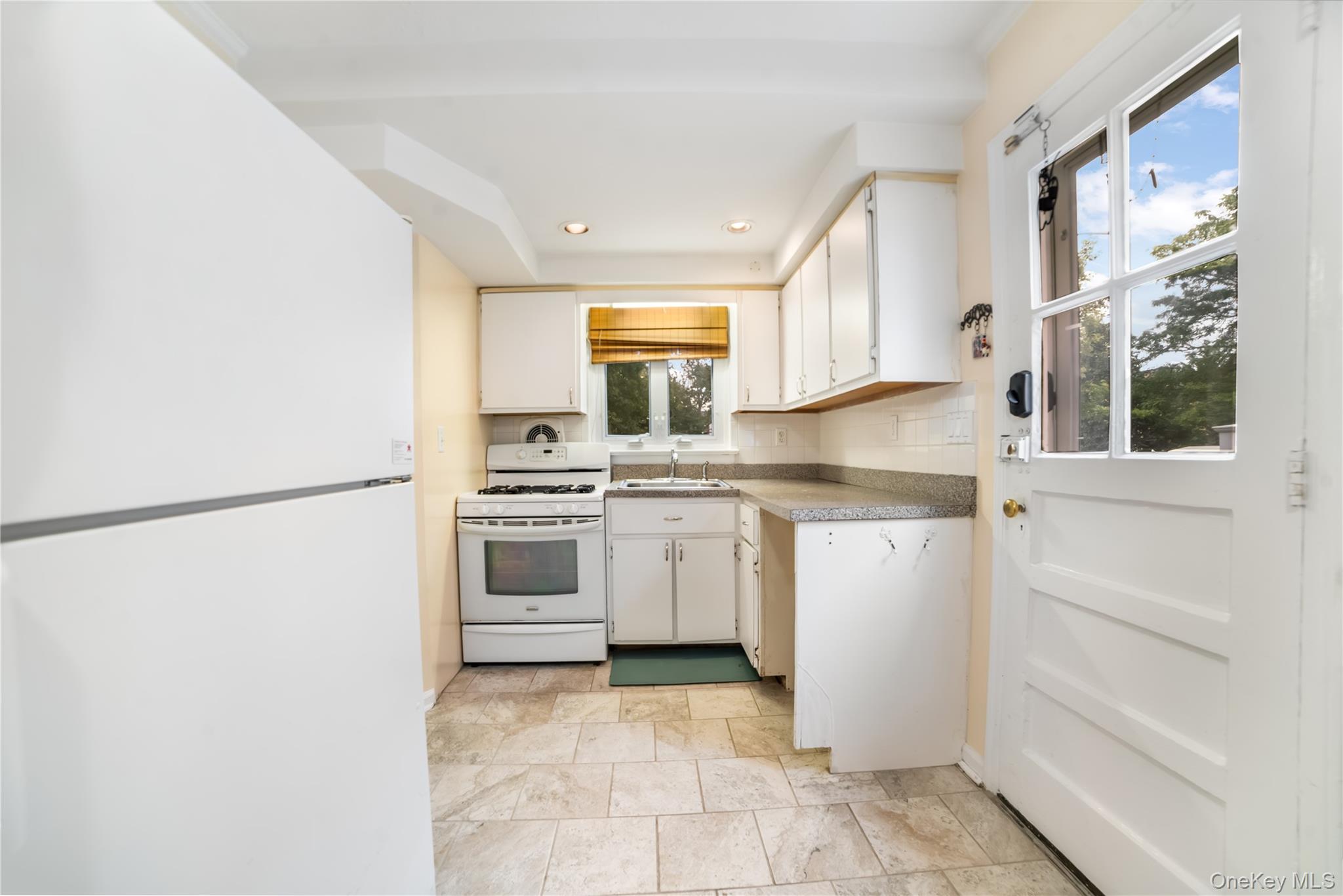77-19 252nd Street Queens, NY 11426 - Photo 10 of 27 a kitchen with white cabinets and white appliances