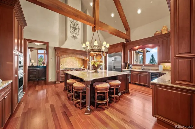 a dining hall with stainless steel appliances granite countertop a stove and wooden floors