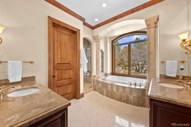 a spacious bathroom with a granite countertop sink and a bathtub