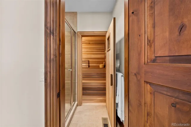 a bedroom with a bed a lamp and a large window with the outer view