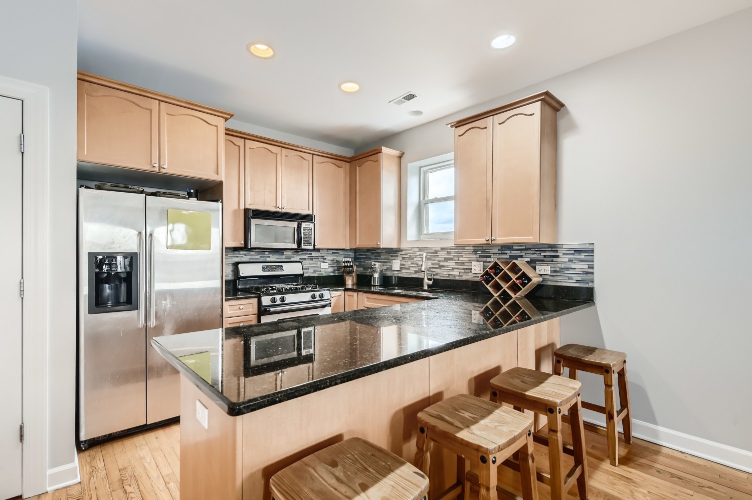 3114 West Irving Park Road, Unit 4E Chicago, IL 60618 - Photo 2 of 18 a kitchen with stainless steel appliances granite countertop a refrigerator a stove and a sink with granite countertops
