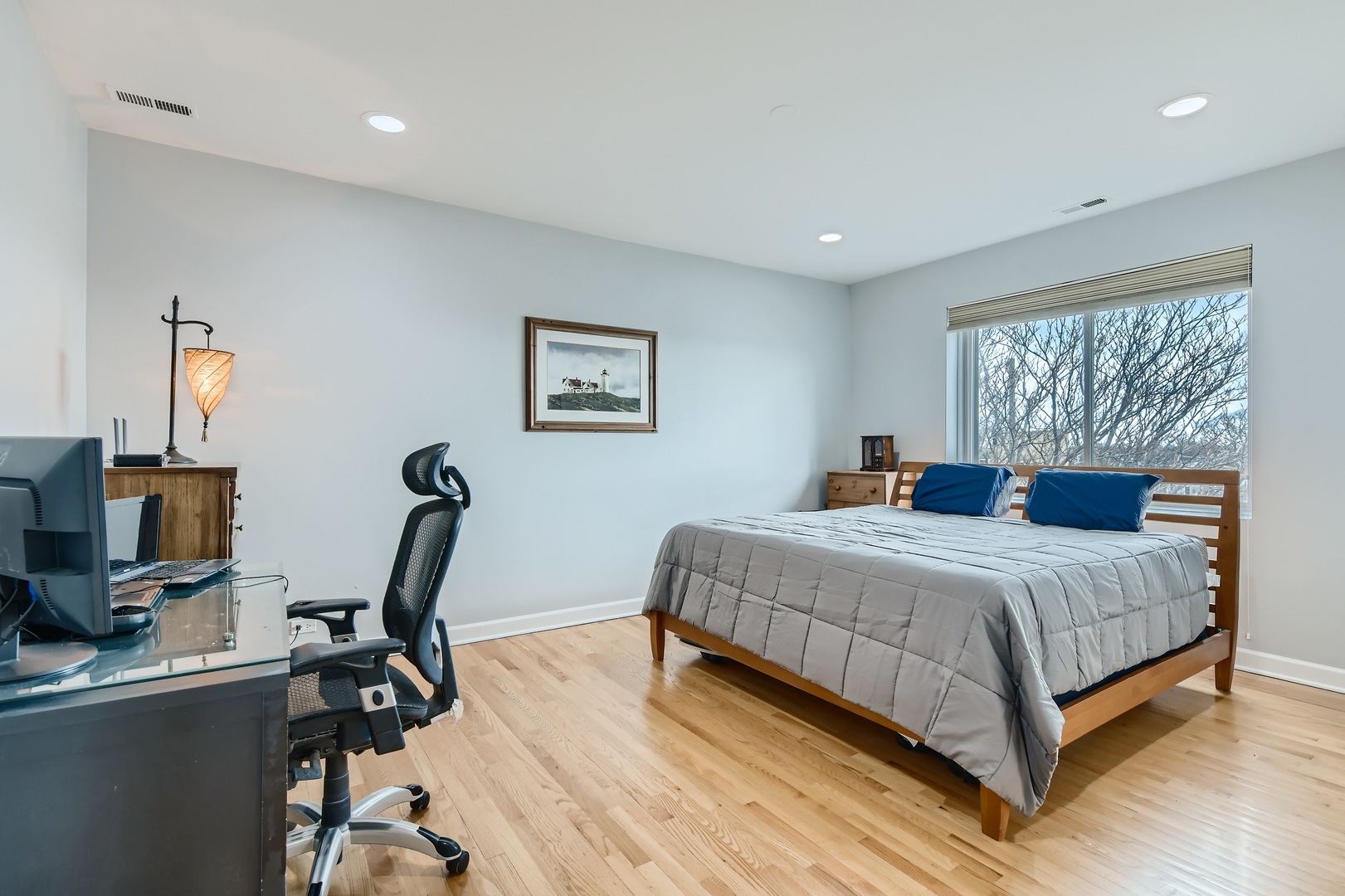 3114 West Irving Park Road, Unit 4E Chicago, IL 60618 - Photo 8 of 18 a bedroom with a bed a window and a flat screen tv