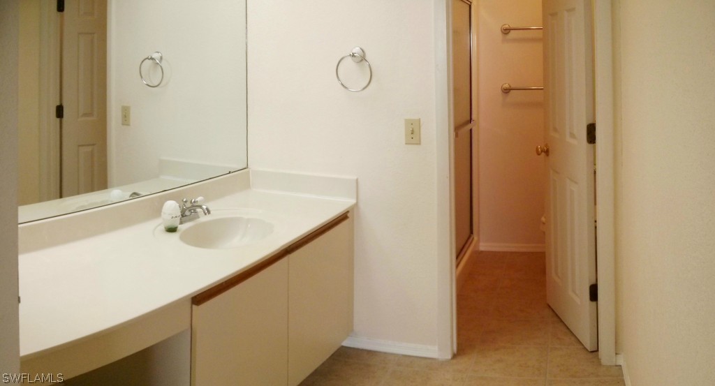 26310 Rampart Boulevard, Unit 505E Punta Gorda, FL 33983 - Photo 11 of 17 a bathroom with a granite countertop sink and a mirror