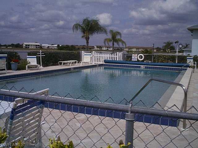 26310 Rampart Boulevard, Unit 505E Punta Gorda, FL 33983 - Photo 17 of 17 a view of a swimming pool with a table and chairs