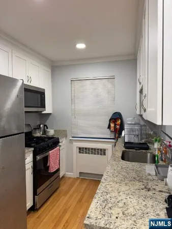 a kitchen with granite countertop a refrigerator stove and sink