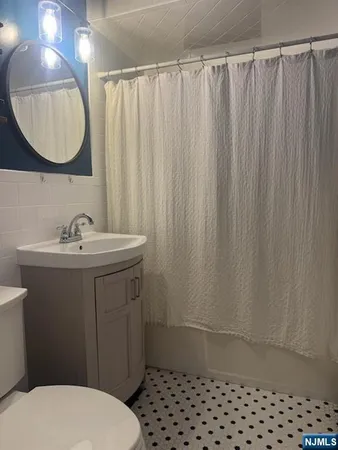 a bathroom with a sink a toilet and a mirror