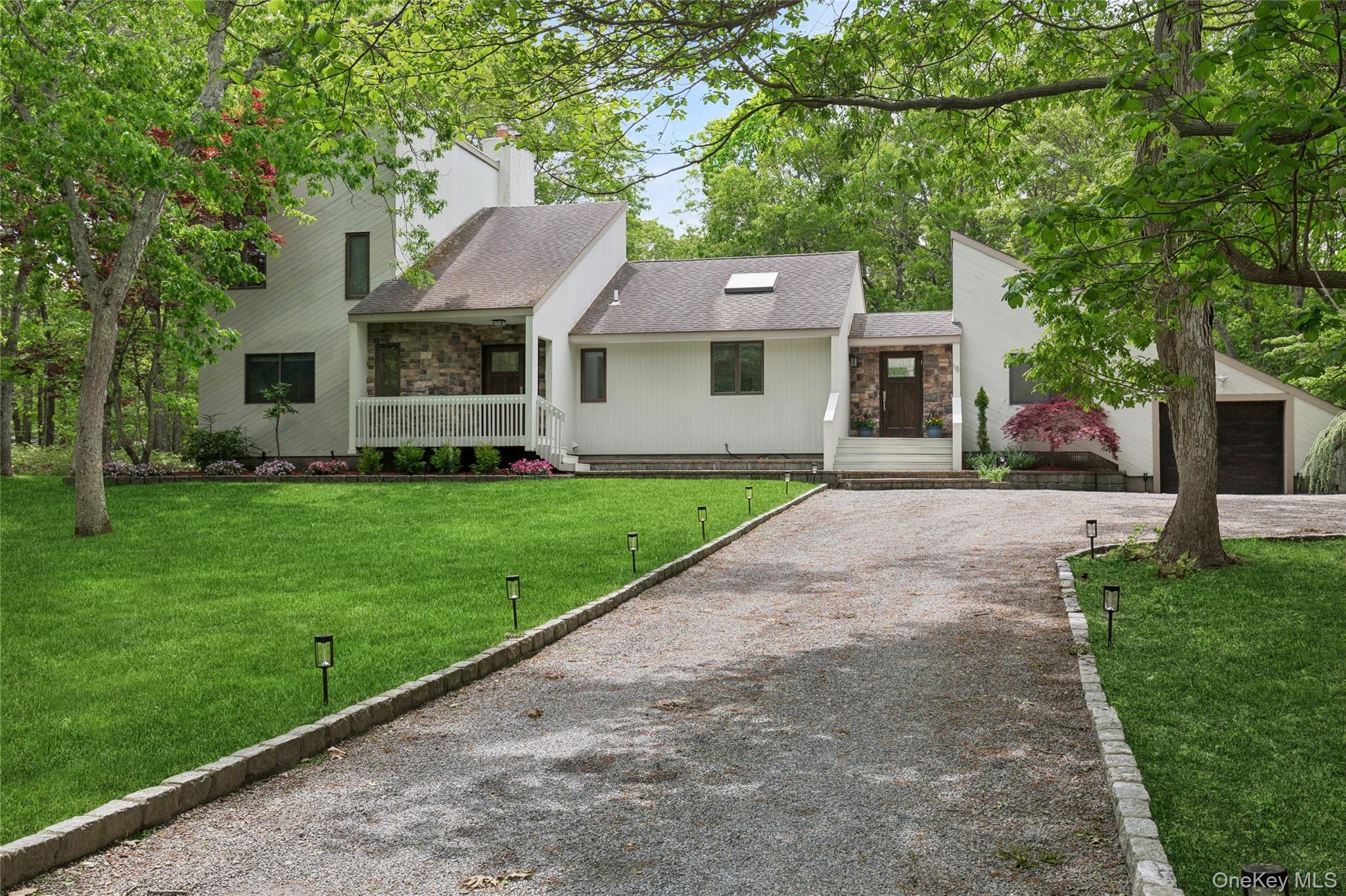 a front view of a house with a garden and yard